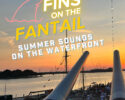 Poster for 'Fins on the Fantail' with sunset harbor scene, silhouettes of people on a ship deck, and bold neon text announcing Summer Sounds on the Waterfront