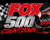 Fox 500 Countdown promotional banner featuring a red-and-black race car and a checkered flag motif on a dark background.